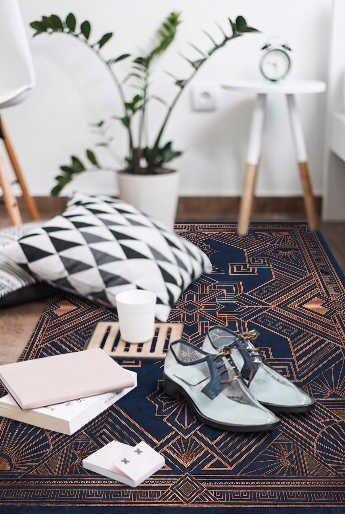 Navy hand-tufted wool rug with a copper Art Deco medallion, sunburst fans and a Greek-key border, close-up with cushions, books and shoes on the rug
